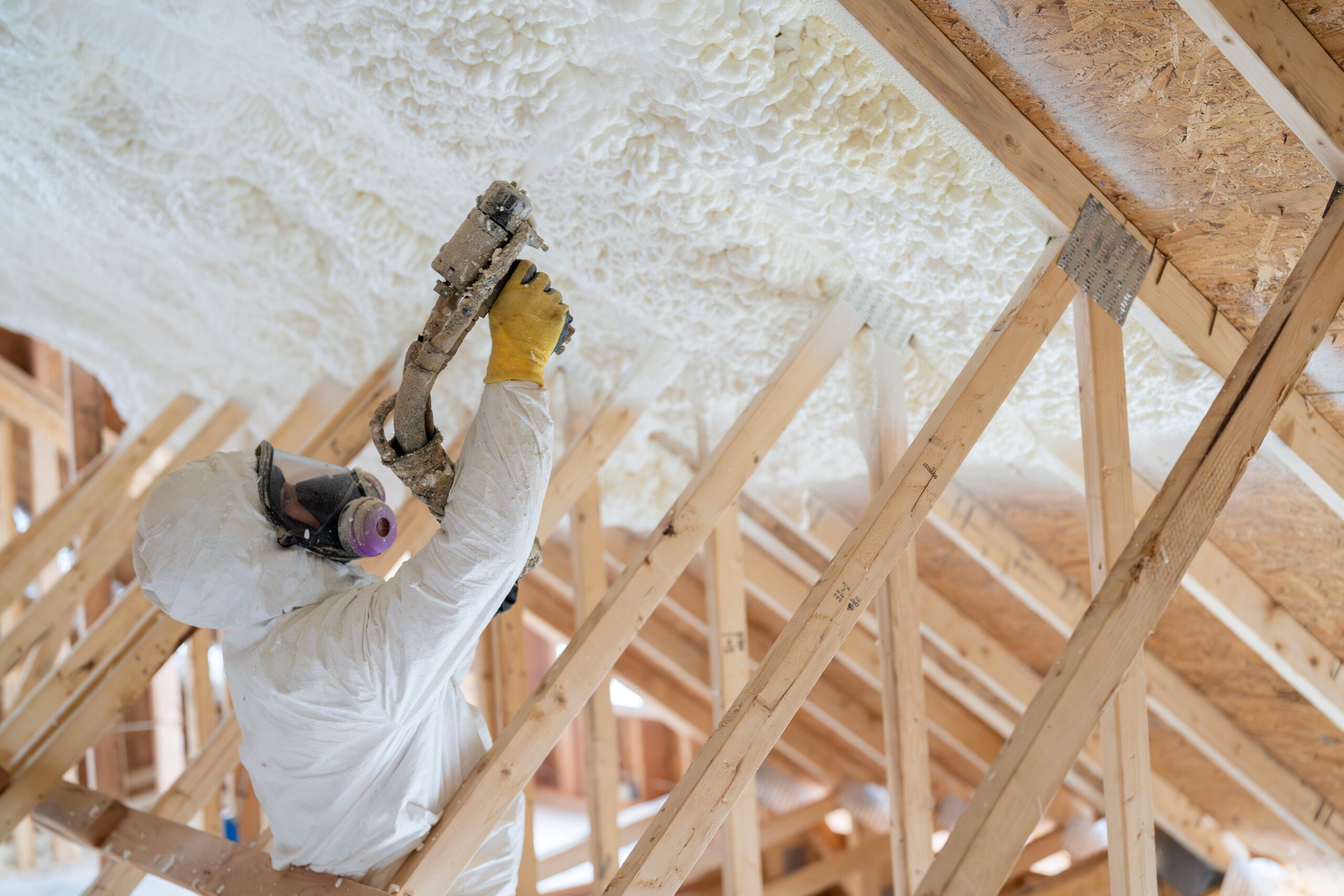 construction worker spraying house insulation